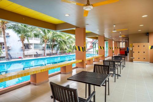 a pool with tables and chairs next to a swimming pool at MeStyle Place Hotel in Bangkok
