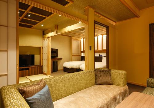 a living room with a couch and a bedroom at Awaji Hamarikyu Takumi in Minamiawaji