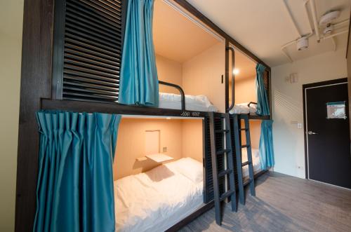 a bedroom with a bed and a window at Loosha Hostel in Taichung