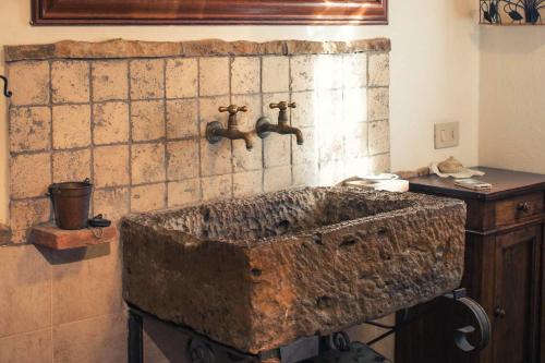 een badkamer met een stenen wastafel met 2 kranen bij CASE&COLLINE Villetta Anita in Montescudaio