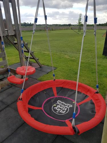 a trampoline with two swings on a patio at 't Nieuwe Nest in Kaatsheuvel