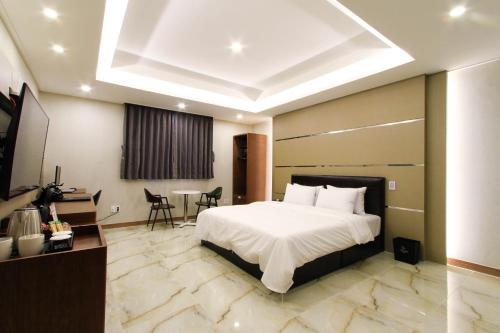 a hotel room with a bed and a table and chairs at The King Hotel in Busan