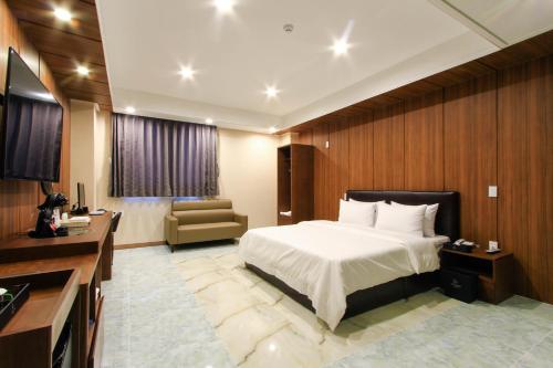 a hotel room with a bed and a chair at The King Hotel in Busan