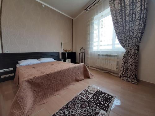 a bedroom with a bed and a large window at Семейные Апартаменты in Pyatigorsk