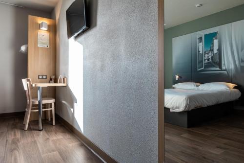 a bedroom with a bed and a table with a table at B&B HOTEL Troyes Magasins d'usine in Troyes