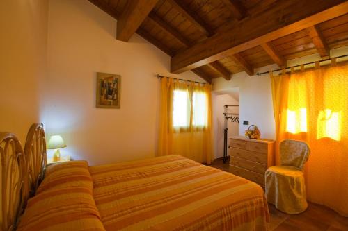 ein Schlafzimmer mit einem Bett, einer Kommode und einem Fenster in der Unterkunft A Domo Mia in Castelsardo