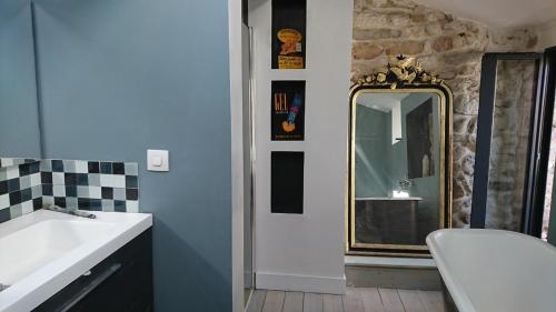 une salle de bain avec un lavabo et un miroir dans l'établissement La maison du brocanteur, à Aiguèze