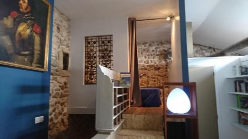 una camera con una scala con una parete di bottiglie di vino di La maison du brocanteur ad Aiguèze
