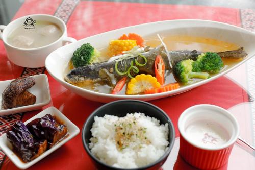 a table topped with a bowl of soup and rice at Wan Lake Coffee Villa in Nanzhuang