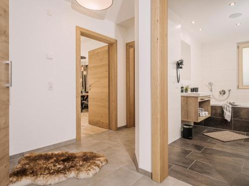 a hallway with a bathroom with a mirror and a rug at Leuhaus in Mayrhofen