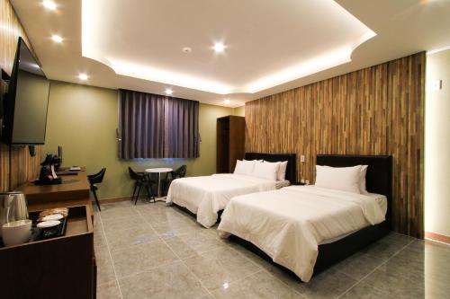 a hotel room with two beds and a table at The King Hotel in Busan