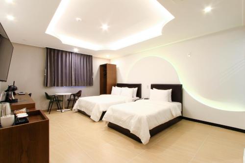 a hotel room with two beds and a television at The King Hotel in Busan