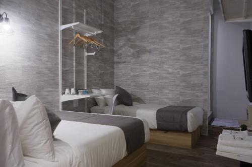a hotel room with two beds and a sink at Q Loft Hotels at Bedok in Singapore