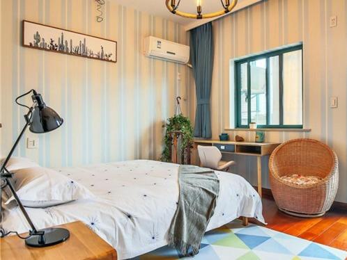 a bedroom with a bed and a desk and a lamp at Hangzhou Yuhang District ·Locals Apartment· Xixi Wetland ·00141260 Locals Apartment 00141260 in Cangqian