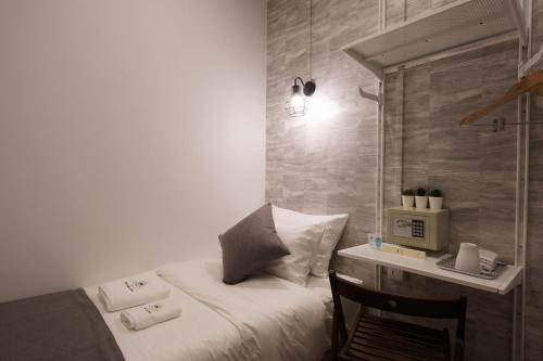 a bedroom with a bed and a desk with a microwave at Q Loft Hotels at Bedok in Singapore