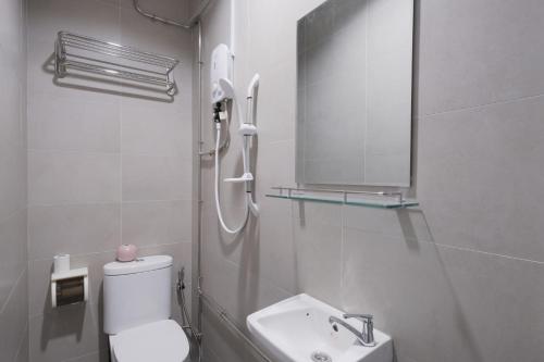 a bathroom with a toilet and a sink and a mirror at Q Loft Hotels at Bedok in Singapore
