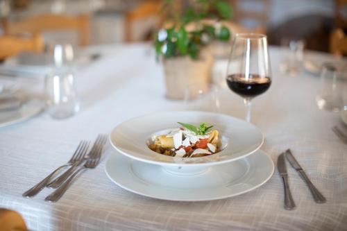 a plate of food on a table with a glass of wine at Leano Agriresort in Piazza Armerina