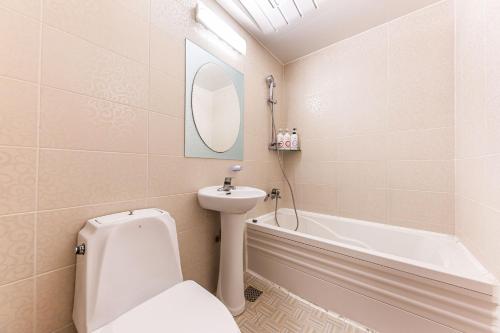 a bathroom with a toilet and a sink and a tub at Su Motel in Buyeo