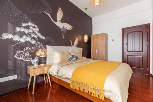 ein Schlafzimmer mit einem Bett und einer Wand mit Vögeln in der Unterkunft Guangzhou Tianhe District·Tianhe another city· in Guangzhou