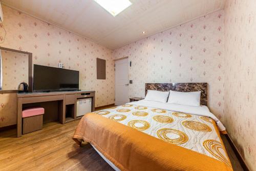a bedroom with a bed and a television in it at Su Motel in Buyeo