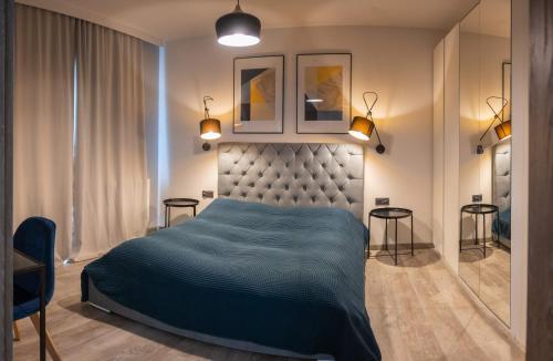 a bedroom with a large bed and two tables at Apartament Victoria 5 Mórz in Sianozety