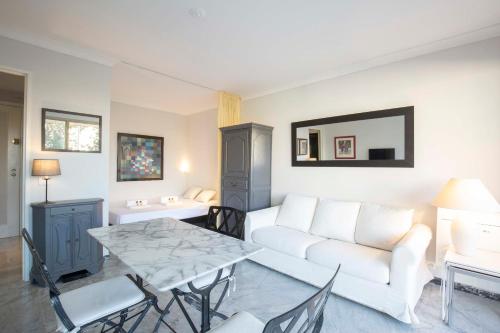 un salon avec un canapé blanc et une table dans l'établissement Chez J-P - 100m beach 2-4pers terrace sea view pool garage, à Antibes