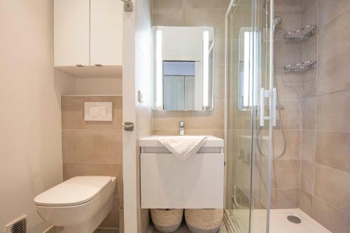 La salle de bains est pourvue de toilettes, d'un lavabo et d'une douche. dans l'établissement BNB RENTING chez J-P - 100m beach 2-4pers terrace sea view pool garage, à Antibes