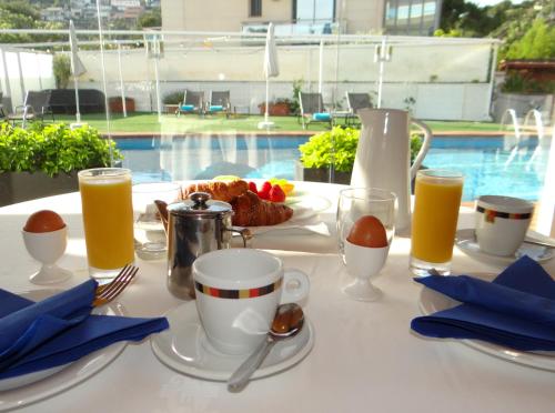 a table with a breakfast of coffee and orange juice at Best Western Hotel Mediterraneo in Castelldefels