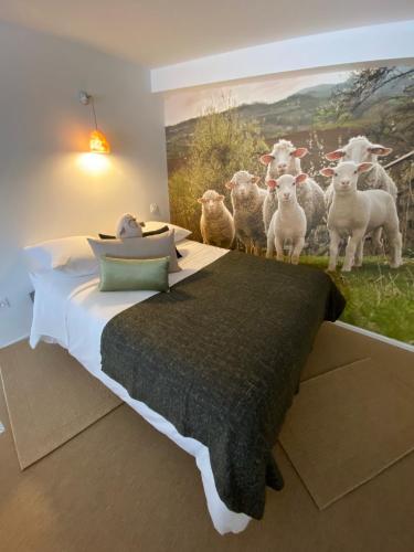 una camera da letto con un dipinto di pecore sul muro di Le Mouton à 5 Pattes Aubagne-Cassis-Aix en Provence a Aubagne