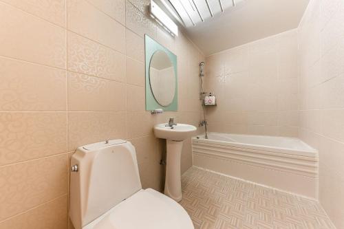 a bathroom with a toilet and a sink and a mirror at Su Motel in Buyeo