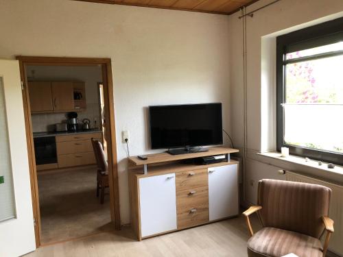 a living room with a flat screen tv on a cabinet at Ferienwohnung Ostseeblick in Insel Poel