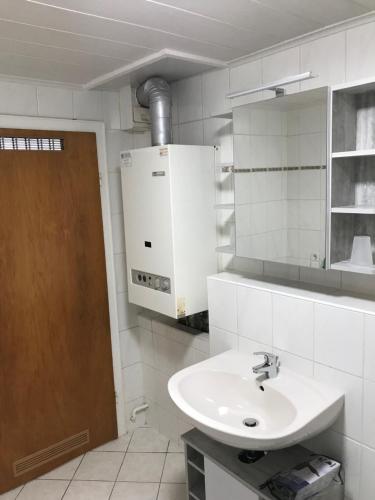 Baño blanco con lavabo y espejo en Cozy Braunlage en Braunlage