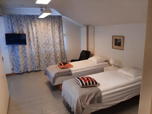 a hotel room with two beds and a chair at Oulun Satamahuoneet in Oulu