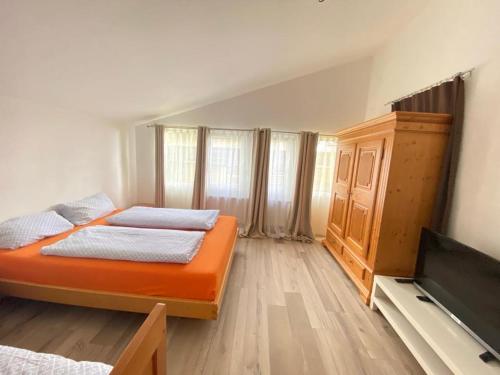 a bedroom with two beds and a flat screen tv at FeWo Henke in Gailingen
