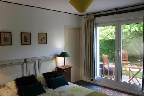 sala de estar con sofá y puerta corredera de cristal en Le Garden Victoria - Canal & Cathédrale -30m2 & Garden, en Nancy