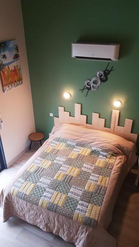 a bedroom with a bed in a green wall at Alolival in Sablonceaux