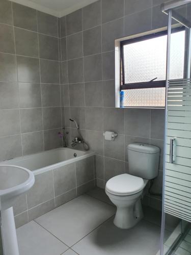 uma casa de banho com um WC, uma banheira e um lavatório. em Zea 85 BnB em Vereeniging