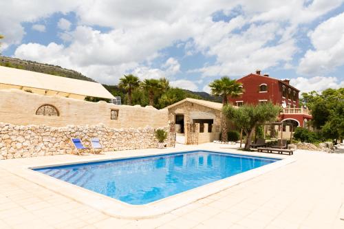 a villa with a swimming pool and a house at Finca Les Coves in Jijona