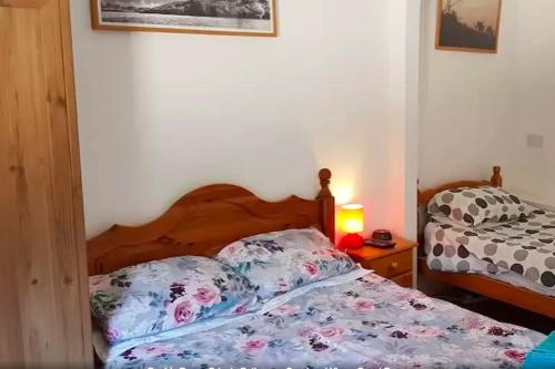 a bedroom with a bed and a night stand with a lamp at Ottleys Guest House in Theydon Bois