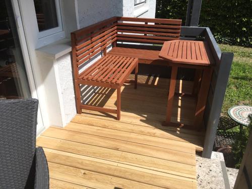 a wooden bench and a table on a deck at Lieblingsnest Detmold in Detmold
