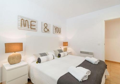 Dormitorio blanco con 2 camas y lámpara en Gala 2, en Tamariu