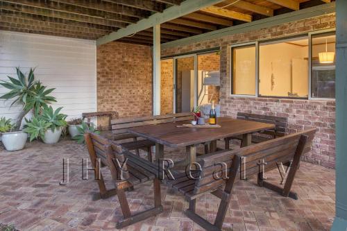a wooden table and benches on a patio at Coastal Cottage in Quindalup