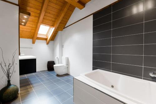 La salle de bains est pourvue d'une baignoire blanche et de toilettes. dans l'établissement Ca la Teresa, à Ribera de Montardit