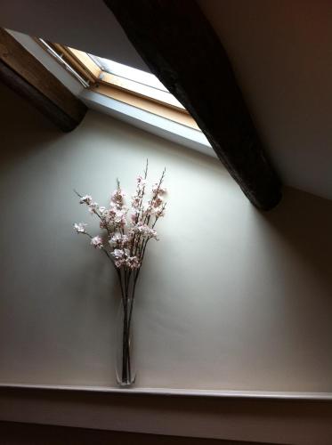 a vase of flowers sitting on a wall under a window at Priory hotel in Cartmel