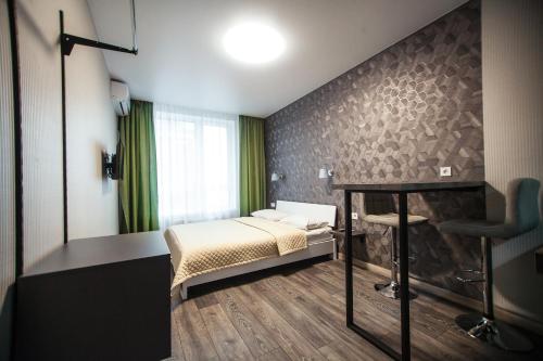 a bedroom with a bed and a desk in it at Solo Apartment Kamenskaya in Kyiv