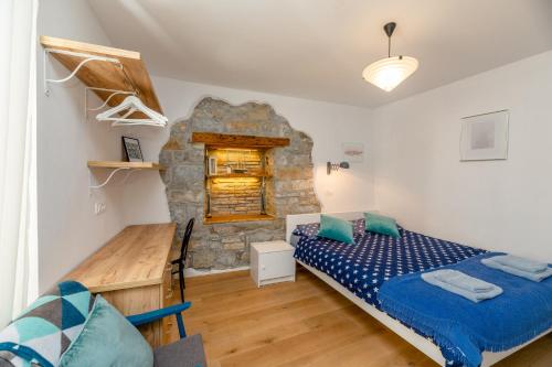 a bedroom with a bed and a stone wall at Nono Mario - Marin in Piran
