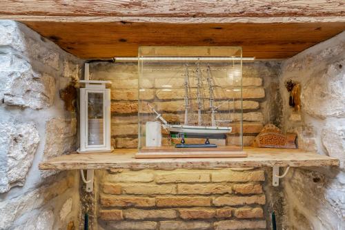 a shelf in a stone wall with a model boat on it at Nono Mario - Marin in Piran