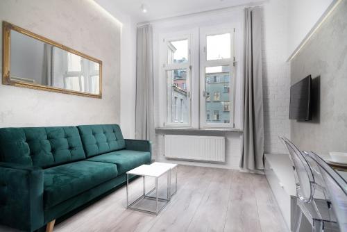 un soggiorno con divano verde e tavolo di RentPlanet - Apartamenty Stare Miasto a Breslavia