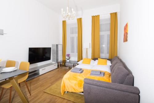 ein Wohnzimmer mit einem Sofa und einem TV in der Unterkunft Rosenstein Apartments by Family & Home in Wien