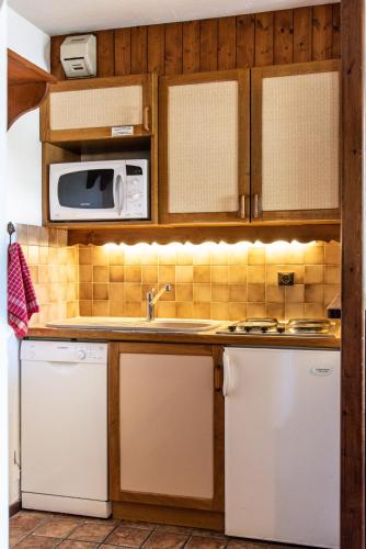a kitchen with a sink and a microwave at Club Alpina - Champagny-en-Vanoise in Champagny-en-Vanoise